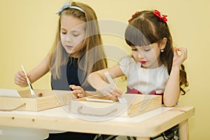 Kids in class create drawing by sand. Children use tassel for rawing. Preschool