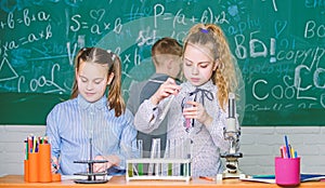 Kids in classroom with microscope and test tubes. Children study biology or chemistry school. School education. School