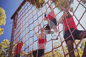 Kids climbing a net during obstacle course training