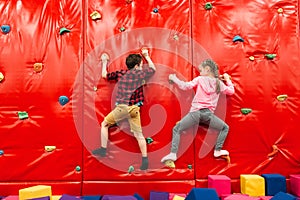 Kids climbing on a wall in attraction playground