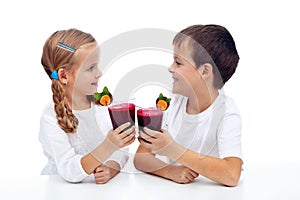 Kids clinking with fresh juice photo