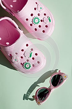 Kids colorful flip flop sandals.Summer vacation composition with pair of pink flip flop sandals, sunglasses on soft