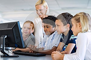 Kids in computer class with teacher