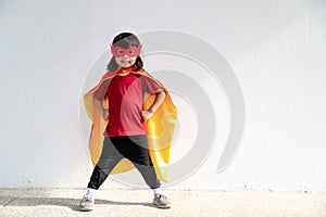 Kids concept, smiling girl playing super hero on white background