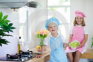 Kids cook in white kitchen. Children cooking