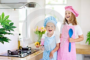 Kids cook in white kitchen. Children cooking