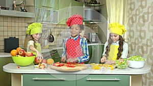 Kids cooking food at table.