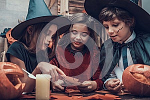 Kids in Costumes Making Halloween Decorations