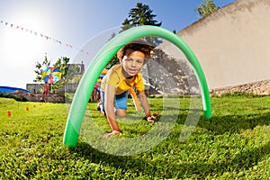 Kids crawl under course of barriers on his fours