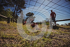 Kids crawling under the net during obstacle course training