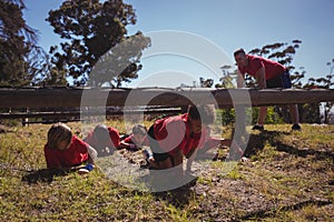 Kids crawling under the net during obstacle course training