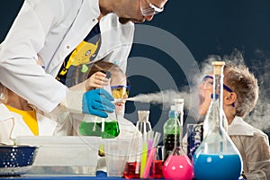 Kids with crazy professor doing science experiments in the laboratory photo