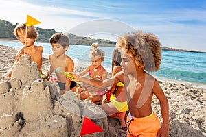 Kids creating sandcastle on the beach in summer