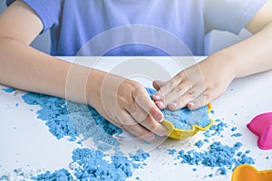 Kids creativity. Kinetic sand games for child development at home. Sand therapy. Children`s hands making moldes. Selective focus, photo