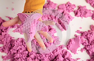 Kids creativity. Kinetic sand games for child development at home. Sand therapy. Children`s hands making starfish photo