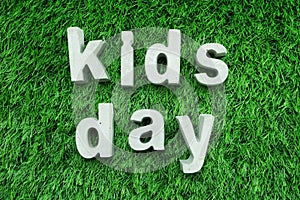 Kids Day made from concrete alphabet on green grass