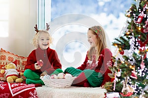 Kids decorate Christmas tree. Child on Xmas eve