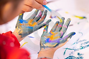 Kids dirty painted hand in art classroom