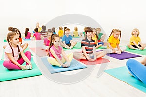 Kids doing butterfly exercise sitting on yoga mats