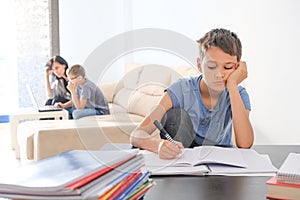 Kids doing school homework at home. Mother helping her teenager son with homework. Online learning, distance learning