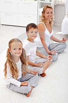 Kids doing yoga relaxation with their mother