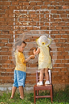 Kids drawing sunny window to a brick wall