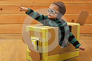 Kids dream. Little boy child play in cardboard plane, childhood. Pilot travel, airdrome, imagination. photo