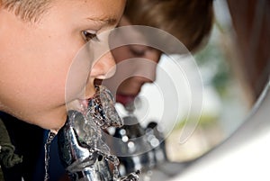 Kids drinking from water fountain