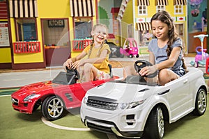 Kids drive car in entertainment center.