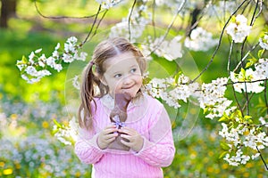 Kids on Easter egg hunt in blooming garden