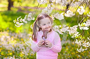 Kids on Easter egg hunt in blooming garden