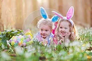 Kids on Easter egg hunt in blooming spring garden