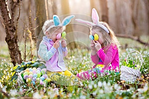 Kids on Easter egg hunt in blooming spring garden