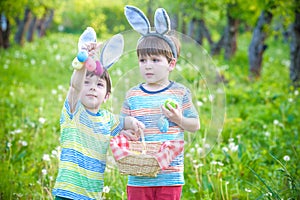 Kids on Easter egg hunt in blooming spring garden. Children sear