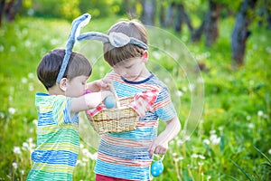Kids on Easter egg hunt in blooming spring garden. Children sear