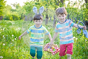 Kids on Easter egg hunt in blooming spring garden. Children sear