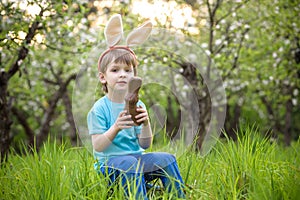 Kids on Easter egg hunt in blooming spring garden. Children searching for colorful eggs in flower meadow. Toddler boy and his brot