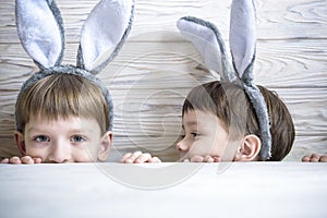 Kids on Easter egg hunt in blooming spring garden. Children searching for colorful eggs in flower meadow. Toddler boy and his brot