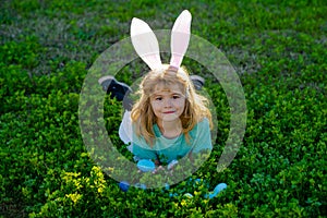 Kids on Easter egg hunt in garden. Children with colorful eggs in grass. Toddler boy play outdoors. Child hunting easter