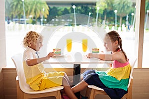 Kids eat cake at restaurant. Boy and girl in cafe