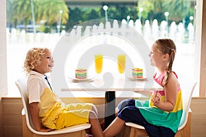 Kids eat cake at restaurant. Boy and girl in cafe