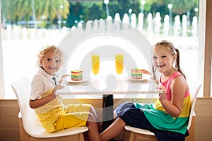 Kids eat cake at restaurant. Boy and girl in cafe