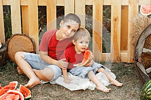 Kids eat fruit outdoors. Healthy snack. Happy family eating watermelon