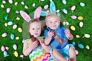 Kids eating chocolate rabbit on Easter egg hunt