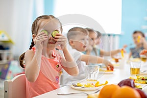 Kids eating healthy food in kindergarten