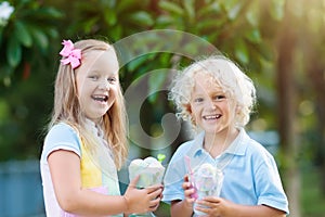 Kids eating ice cream. Child with fruit dessert.