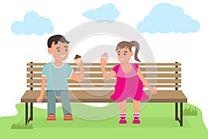 Kids Eating Ice Cream in a Park. A boy and a girl are sitting on a bench in the park