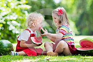 Kids eating watermelon in the garden