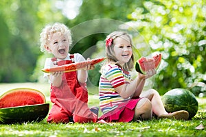 Kids eating watermelon in the garden