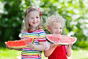 Kids eating watermelon in the garden